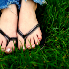 Feet Wearing Flip Flops in the Grass