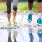 Couple Jogging Through Puddles In Bright Athletic Shoes