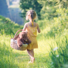 Barefoot Girl Walking In Field With Basket and Teddy Bear