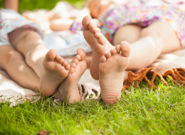 Girls Laying In the Park Barefoot On A Blanket