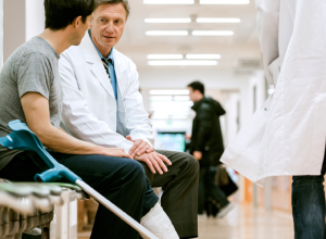 Man In A Cast Speaking With A Doctor 