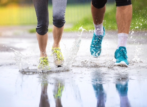 Couple Jogging Through Puddles In Bright Athletic Shoes