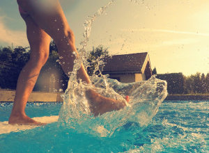 Woman Kicking Her Foot and Leg In Swimming Pool Water