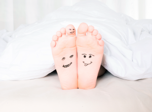 Feet with ink drawings of facial expressions