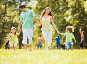 Family Running In A Grassy Park