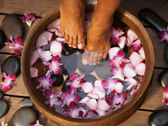 Woman&#039;s Feet In Basin Of Orchid Flower Water
