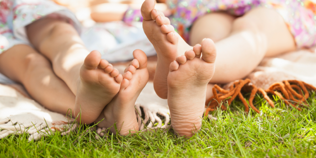 Girls Laying In the Park Barefoot On A Blanket