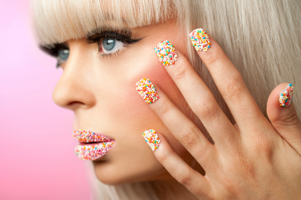 Woman With Colorful Cake Sprinkles On Her Fingernails and Lips