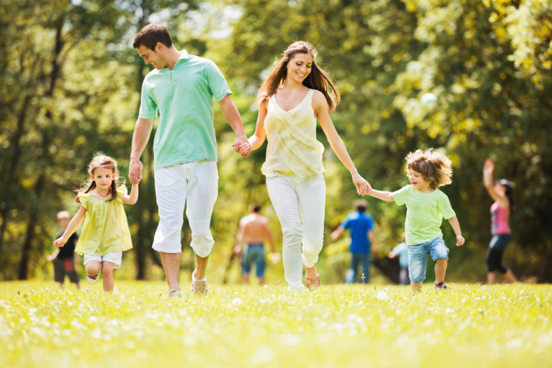 Family Running In A Grassy Park