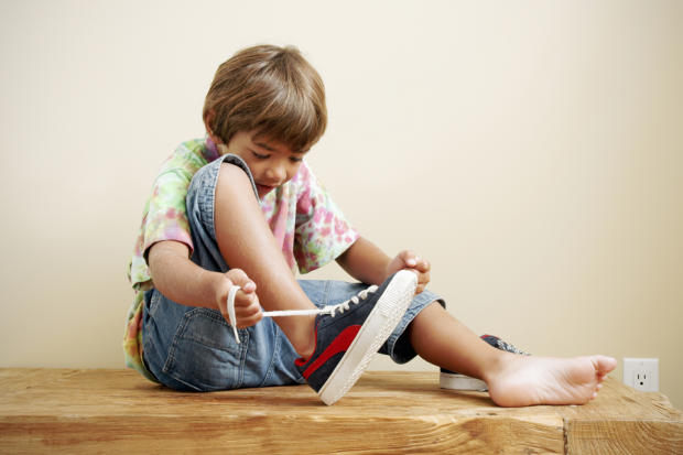 when does a kid learn to tie shoes