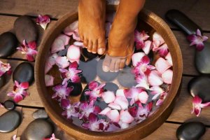 Woman&#039;s Feet In Basin Of Orchid Flower Water